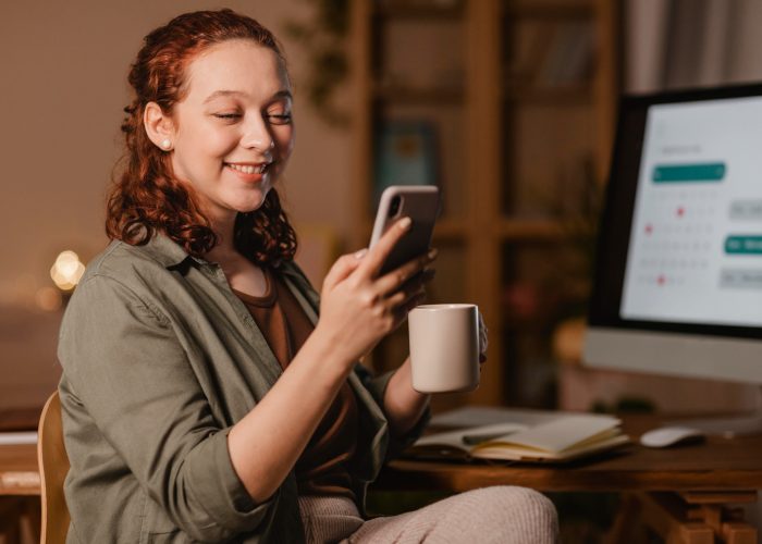 woman-home-using-smartphone-front-computer-while-having-coffee.jpg